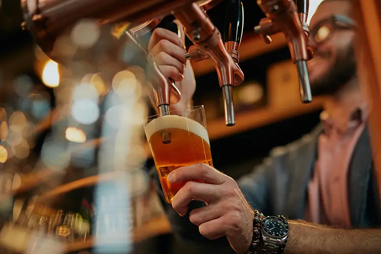 Man pouring a glass of beer at a brewery