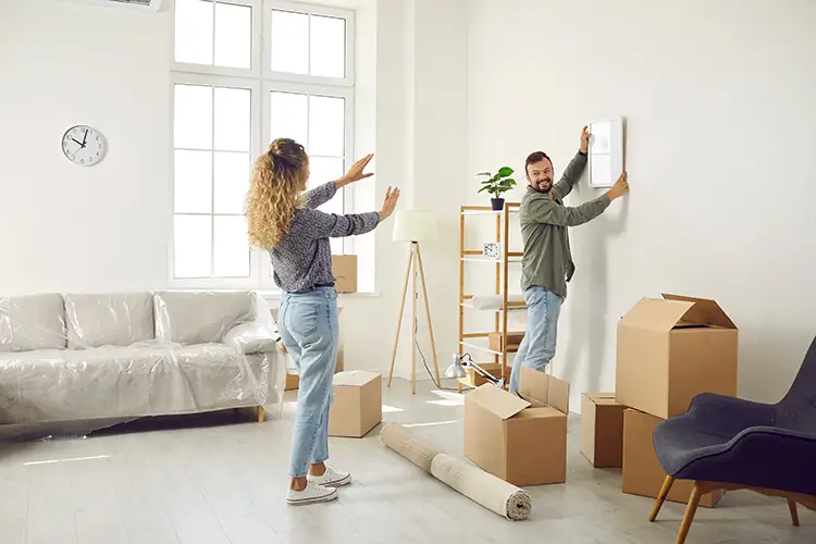 Young couple coordinating on furniture placement in the room
